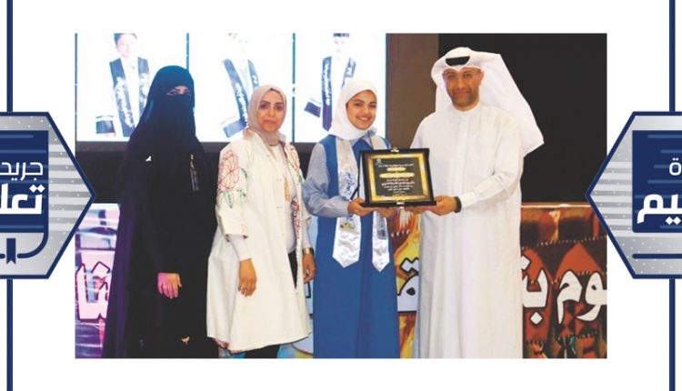 جاسم بوحمد مكرما احدى الطالبات المشاركات في المسابقة ﻿